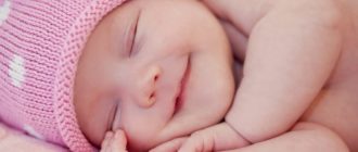 спящий младенец в розовой шапочке